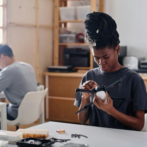 African American Woman Repairing Quadcopter in Workshop