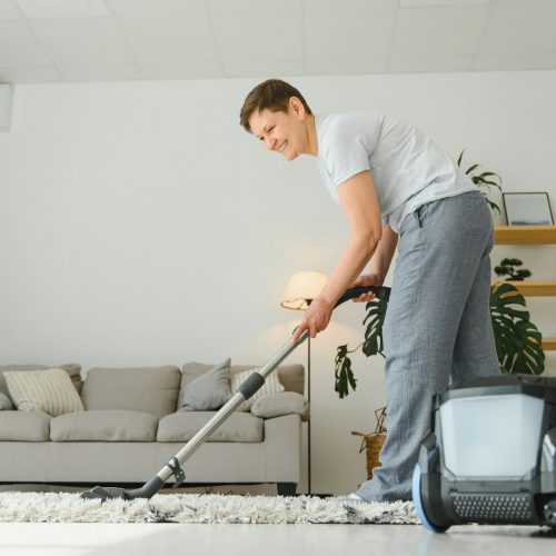 Cleaning concept. woman cleaning carpet with vacuum cleaner.