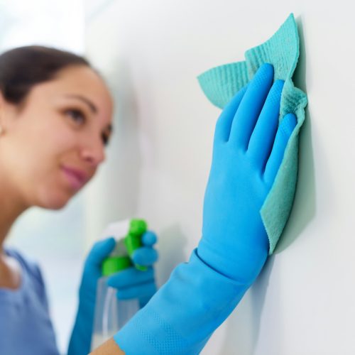 Woman cleaning walls at home