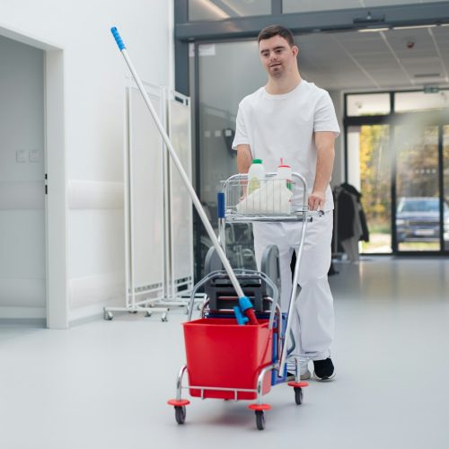 Young man with down syndrome working in a hospital as cleaner. Concpet of integration people with